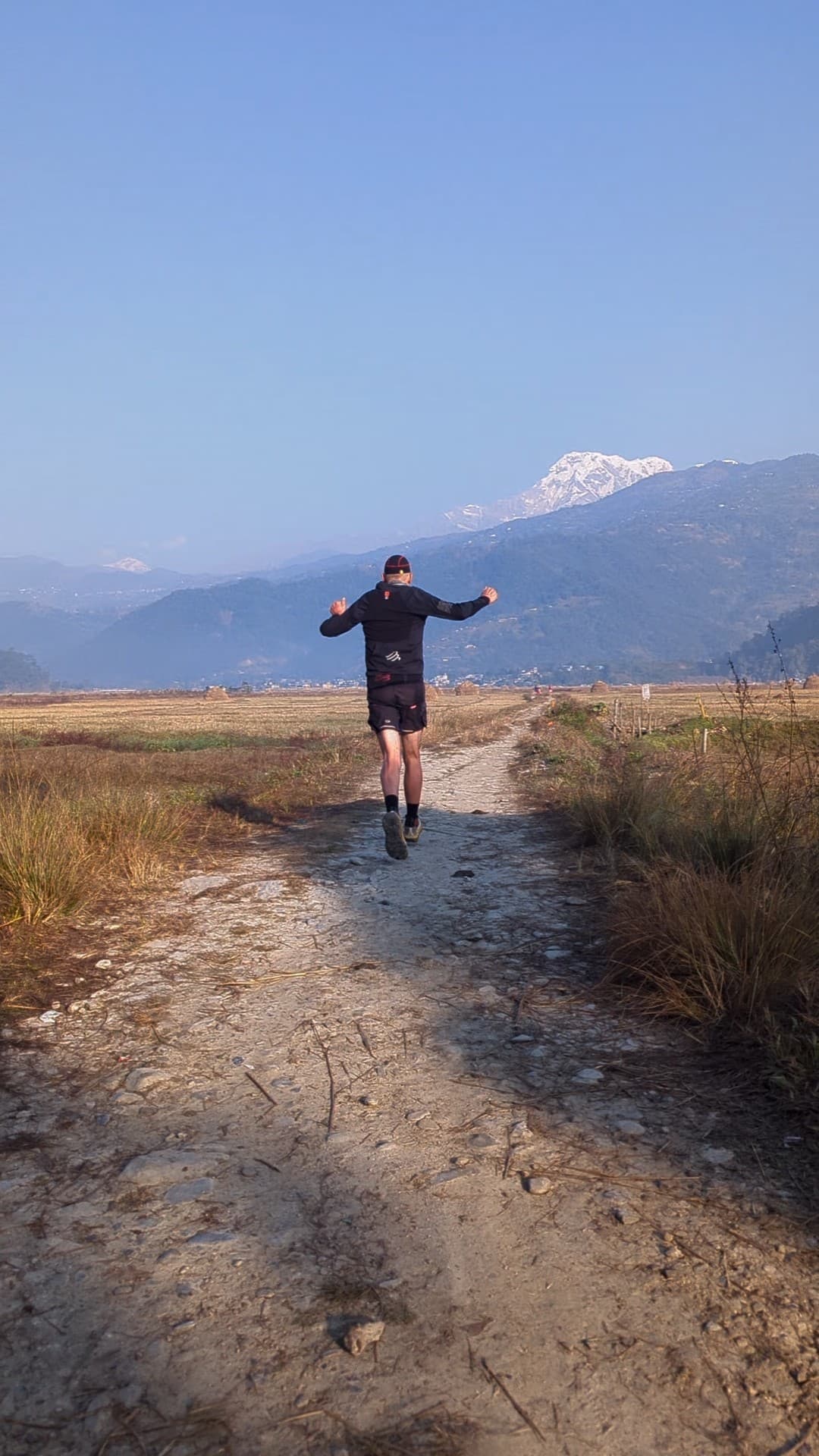 Runner on Pokhara trail with Annapurna mountains