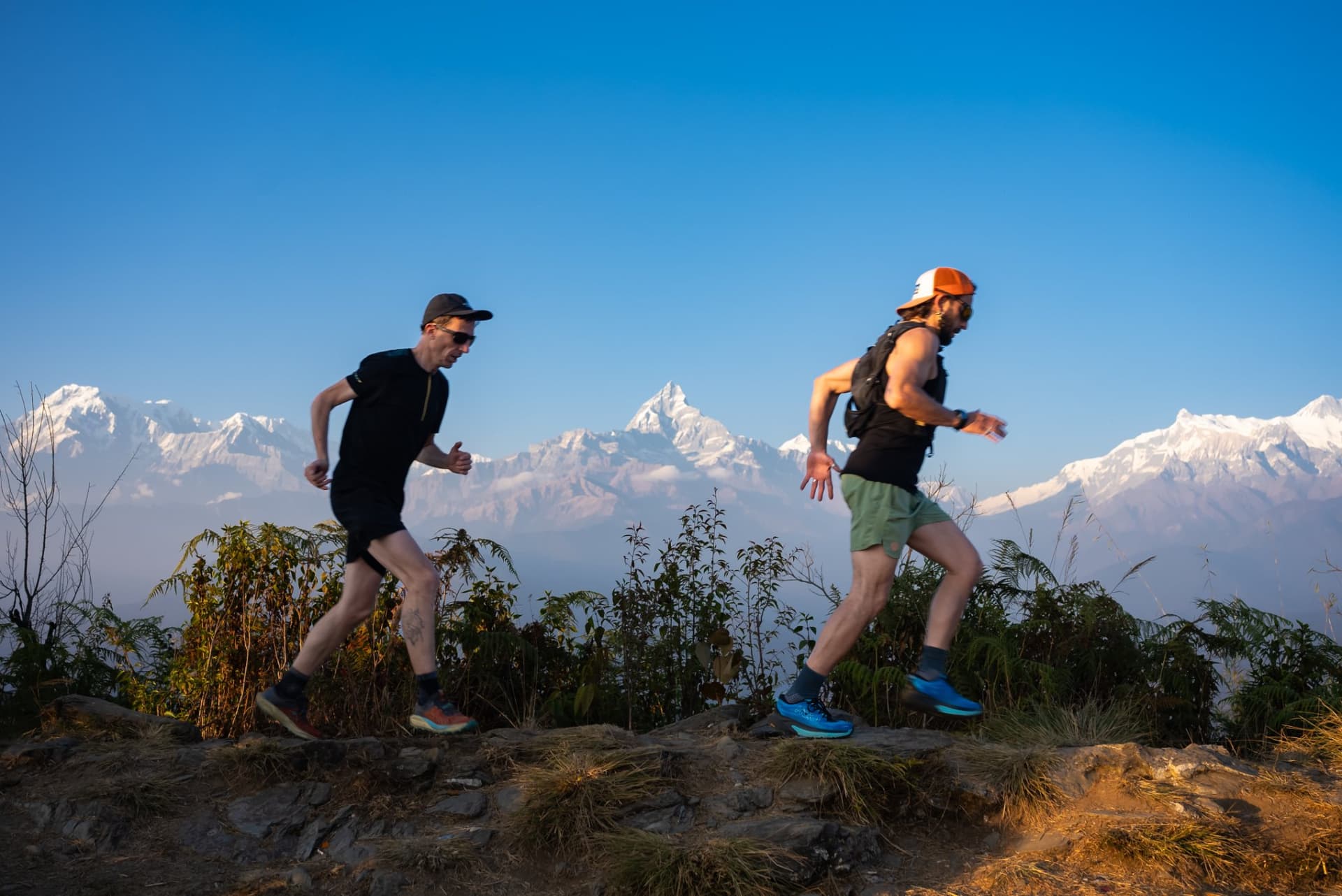 Two trail runners on the ridge above Pokhara with the Annapurna range
