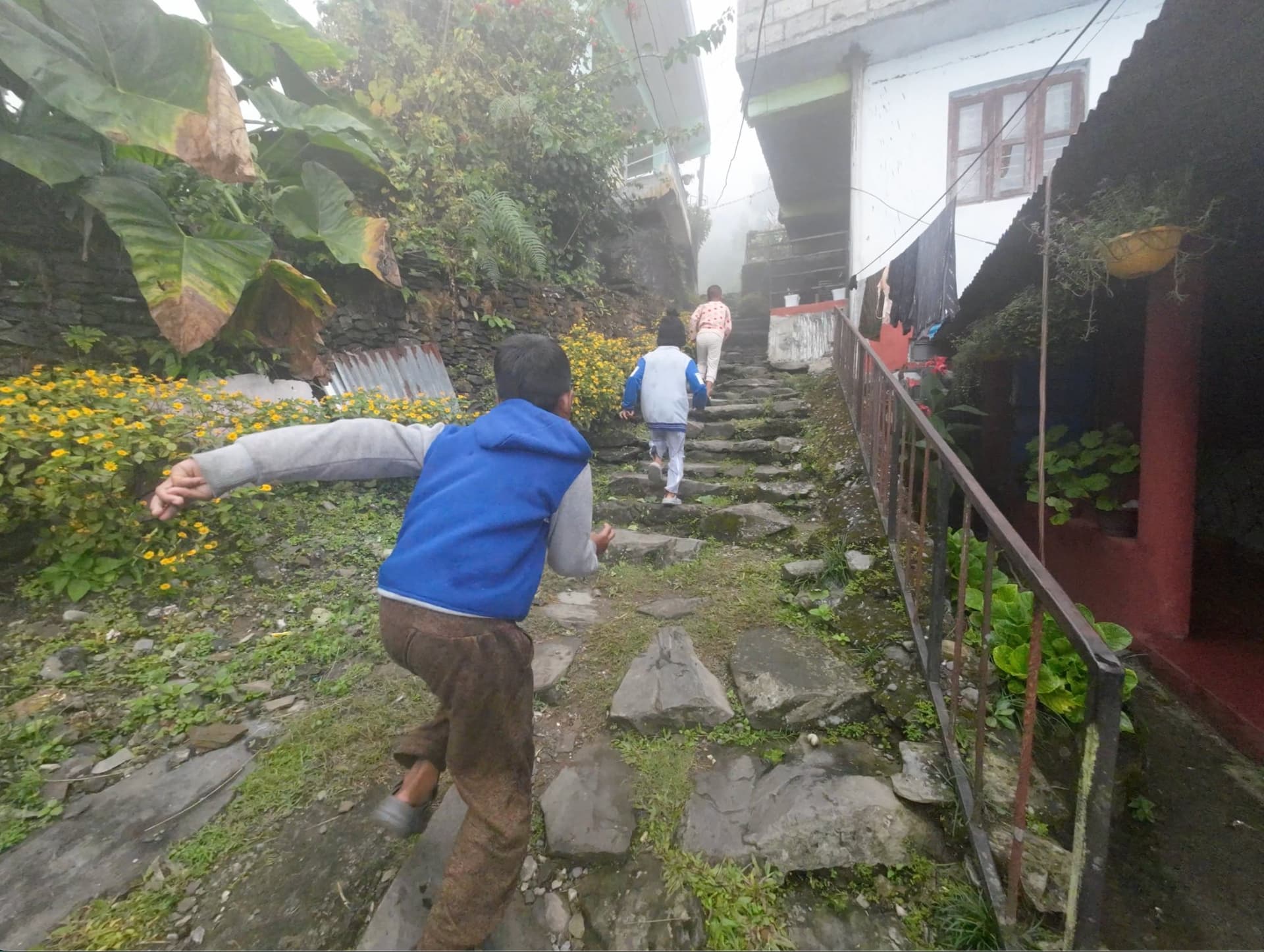 Children running in an authentic Nepali village on the Sarangkot trail